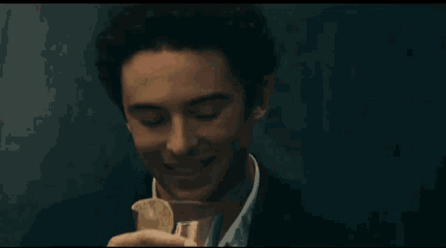a man is drinking a martini with a slice of lime