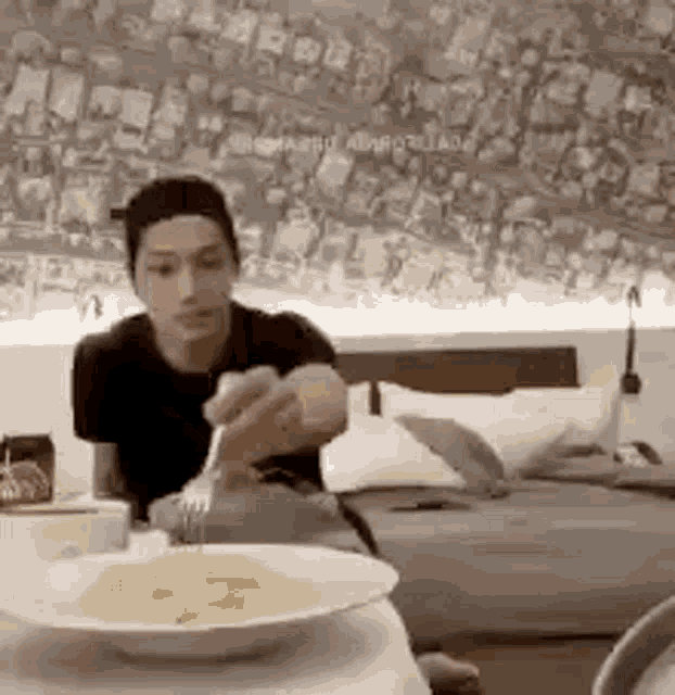 a man is sitting at a table with a plate of food on it .