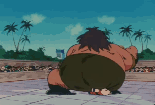 a sumo wrestler is squatting down in front of a crowd
