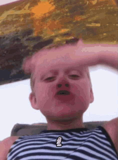 a young boy wearing a black and white striped shirt with the letter s on it