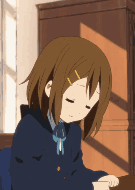 a girl with her eyes closed is wearing a blue jacket