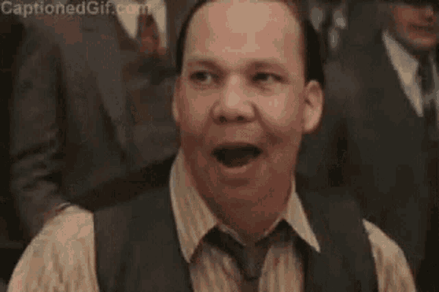a man in a suit and tie is making a funny face .