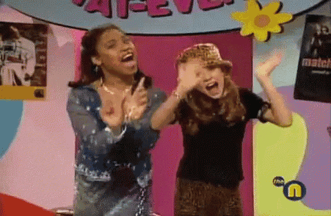 two girls are dancing in front of a sign that says match on it