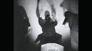 a black and white photo of a person standing in front of a wall with their hands up .