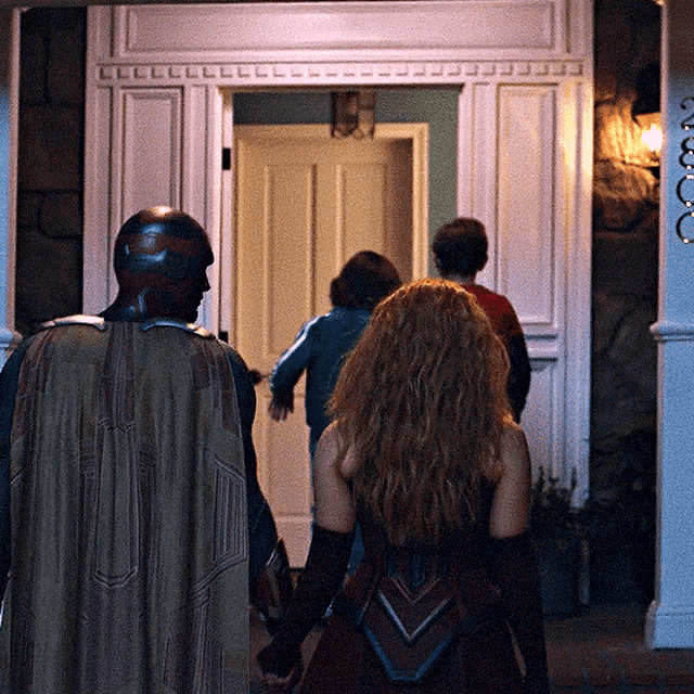 a group of people are walking into a house