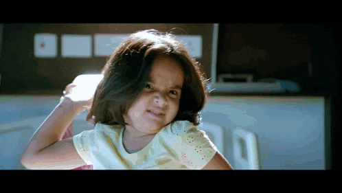 a little girl making a funny face with her hair