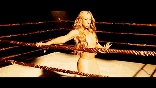 a woman is standing in a boxing ring with a rope around her waist