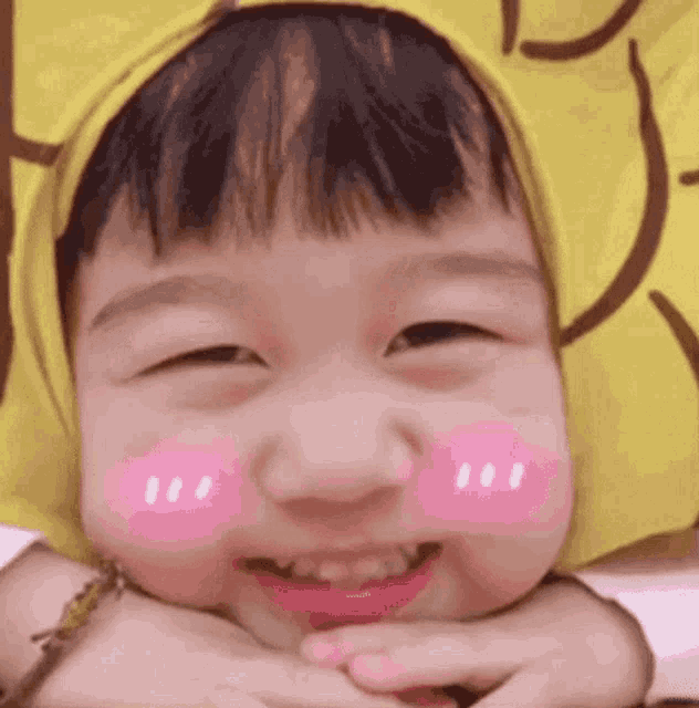 a little boy wearing a yellow hat and a pink cheek .