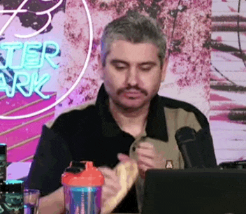 a man is sitting at a table with a microphone and a laptop .