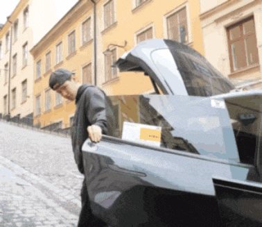 a man standing next to a car with the trunk open and a sticker on it that says ' a ' on it