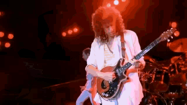 a man is playing a guitar on a stage in a band .