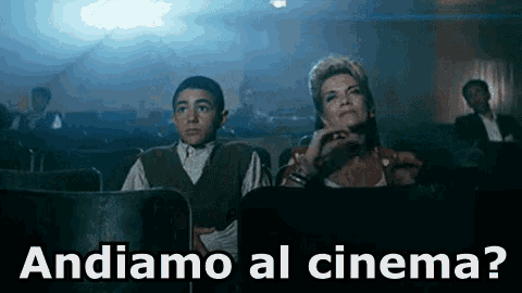 a man and a woman are sitting in a movie theater with the words andiamo al cinema
