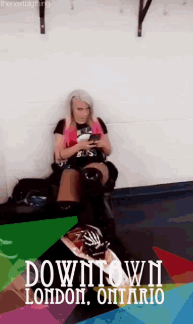 a woman is sitting on a couch in downtown london ontario looking at her phone