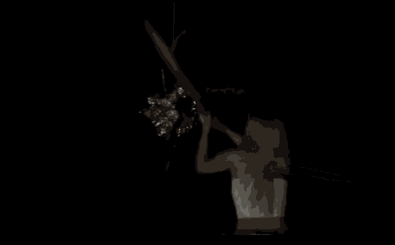 a woman is standing in the dark holding a stick .