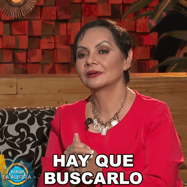 a woman in a red shirt says hay que buscarlo in spanish