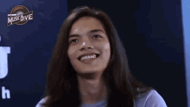 a woman with long hair is smiling with her tongue out .