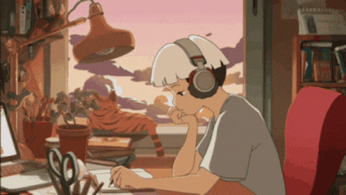 a girl wearing headphones sits at a desk