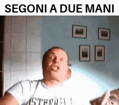 a man in a white shirt is making a funny face with the words segoni a due mani below him