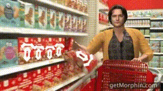 a woman in a yellow cardigan is pushing a red shopping cart in a grocery store ..