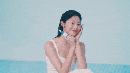 a close up of a woman 's face with blue water in the background