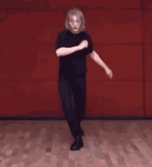 a man is dancing on a wooden floor in a dance studio .