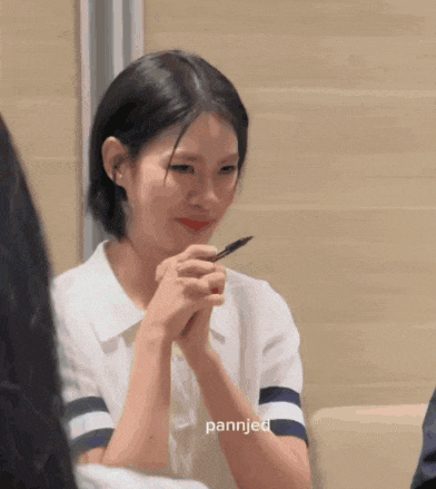 a woman is holding a pen in her hand and the name pannjed is on the bottom of the picture