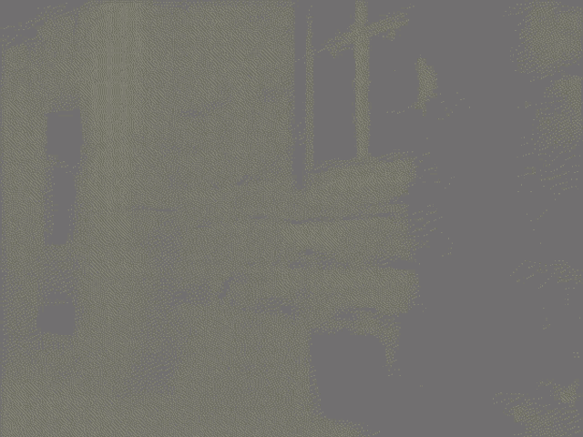 a woman is standing on the side of a building at night with a yellow sign that says caution