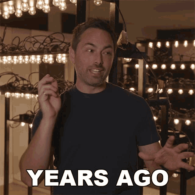 a man is standing in front of a wall of lights and says years ago