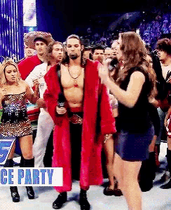 a man in a red robe stands in front of a crowd with a sign that says " ice party "
