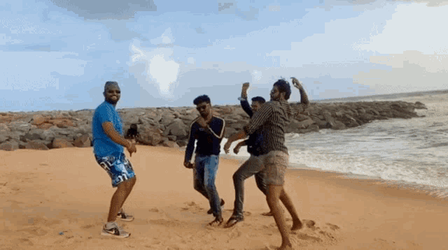 a group of men are dancing on a beach