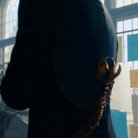 a man in a suit is holding a statue of a dragon behind his back
