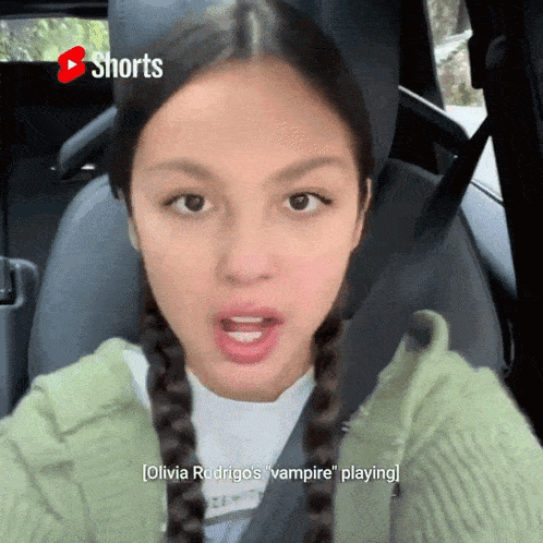 a woman in a car with shorts written on the screen
