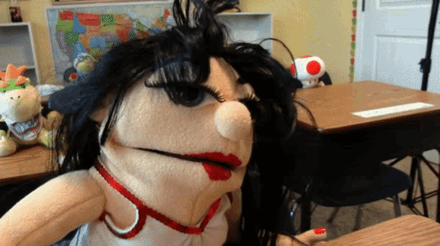 a puppet sitting at a desk with a map of the united states in the background