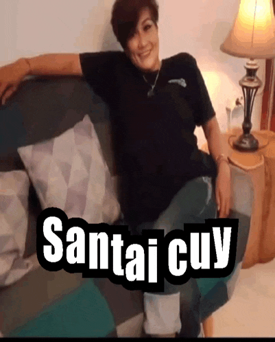 a woman is sitting on a couch with santai cuy written in white letters