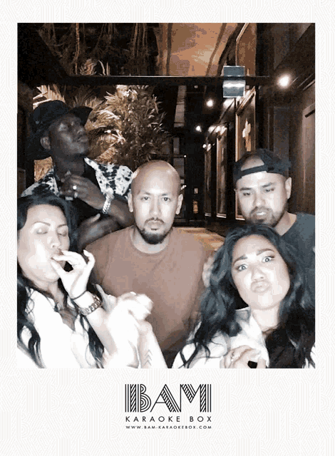 a group of people are posing for a picture with the karaoke box logo
