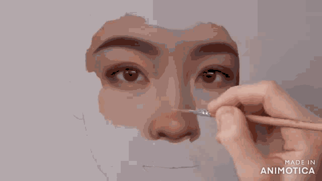 a person is painting a woman 's face with a brush and the words made in animotica are on the bottom