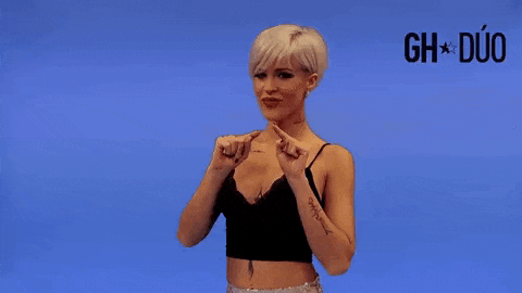 a woman with short blonde hair is wearing a black crop top .