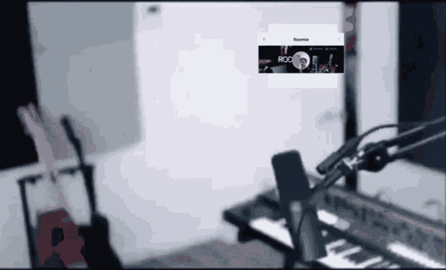 a microphone is sitting in front of a keyboard in a room with a screen that says roc