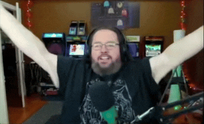 a man with his arms outstretched in front of a microphone in front of an arcade