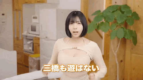 a woman in a white dress is standing in a kitchen with chinese writing on the wall .