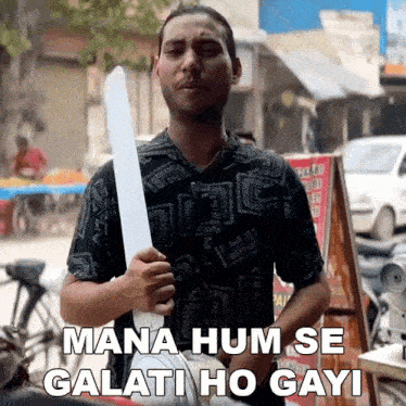 a man in a black shirt is holding a paper fan and says " mana hum se galati ho gayi "
