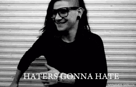 a black and white photo of a man wearing glasses and a black shirt with the words `` haters gonna hate '' .