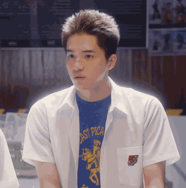 a young man wearing a white shirt and a blue shirt that says east pica