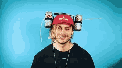 a man wearing a hat with beer cans on it .