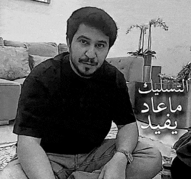 a man is sitting on the floor in front of a couch in a living room .
