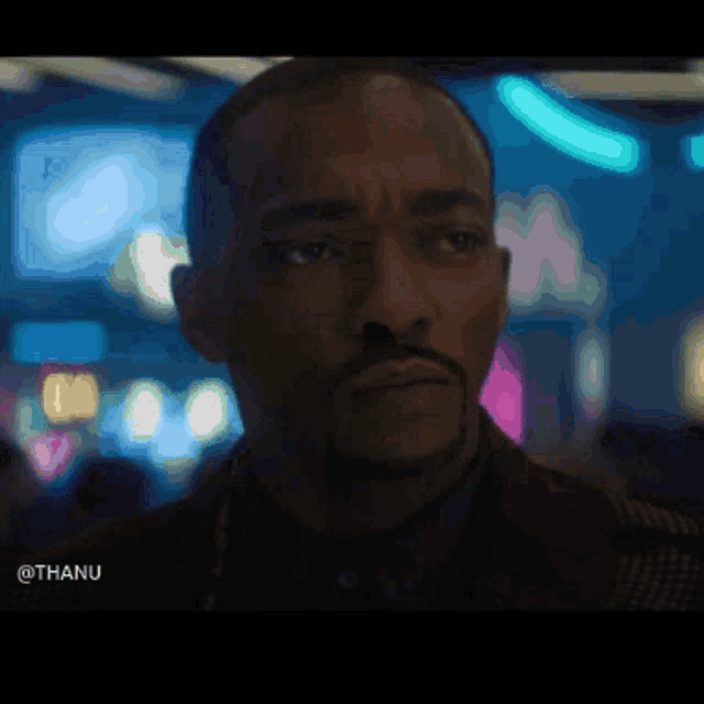 a close up of a man 's face with a blurry background and the word thanu at the bottom