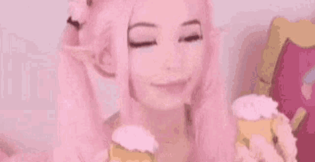 a woman in a pink wig is eating a donut .