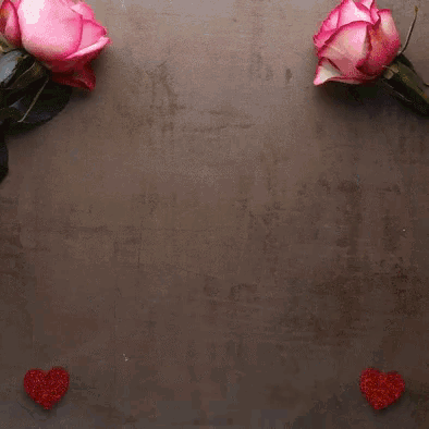 a plate of heart shaped cookies sits on a table next to pink roses