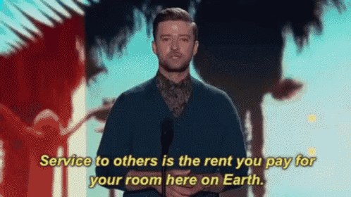 a man is standing in front of a microphone and says service to others is the rent you pay for your room here on earth .