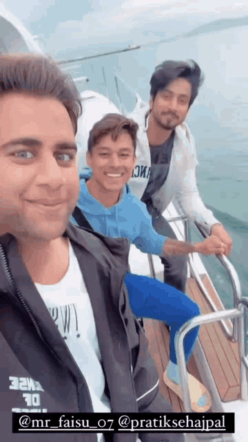 three men on a boat with one wearing a jacket that says ' mr_faisu_07 ' on it